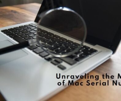A magnifying glass resting on an open laptop keyboard with the screen displaying the text “Unraveling the Mystery of Mac Serial Numbers.